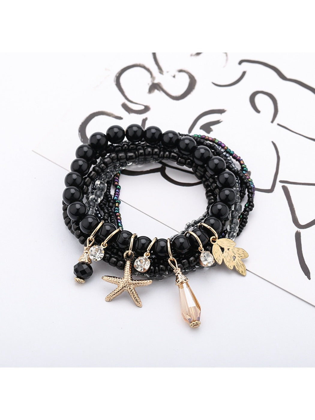 Multiple Lovra stackable bracelets layered on wrist featuring ocean-themed pendants