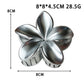 Beau flower shaped claw clip held in hand showing size and scale