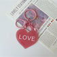Multiple solid color heart-shaped pendant keychains in various colors on keyrings