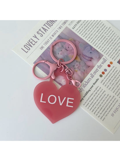 Multiple solid color heart-shaped pendant keychains in various colors on keyrings