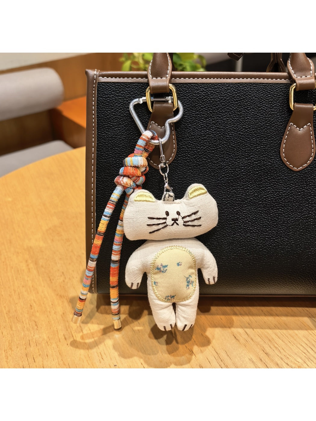 Keypus bunny charm keychain with pink ears and smiling face on a plain surface