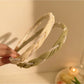 Side view of delicate beaded headband featuring tiny white beads on thin gold band