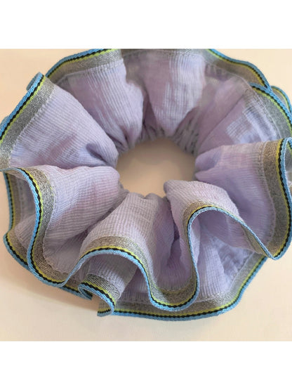 Purple scrunchie styled on a wrist as a bracelet