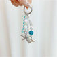 Ocean themed pendant keychain displayed on a wooden surface with natural lighting