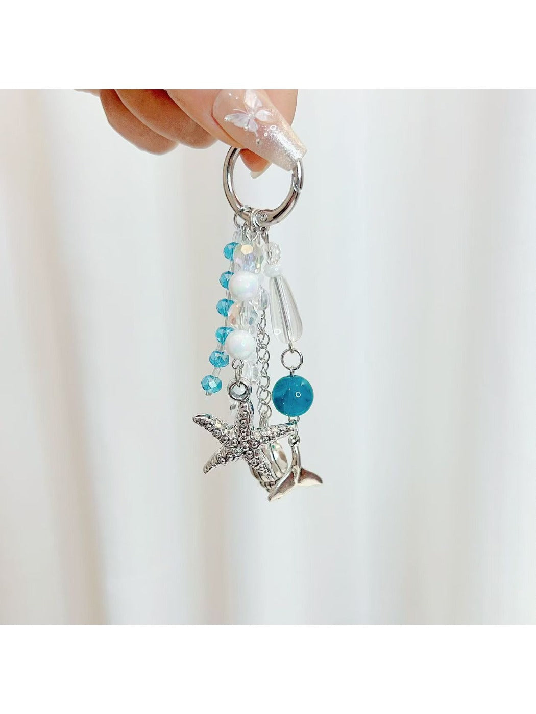 Ocean themed pendant keychain displayed on a wooden surface with natural lighting