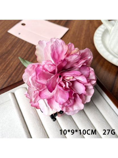 Close-up of the claw mechanism of Beau peony flower hair clip in soft pink