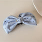 Beau elegant bow banana clip in black, angled view showing glossy finish