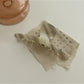 Beau chic acetate claw clip resting on a wooden surface with natural light