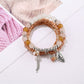 Side view of Lovra alloy pendant bracelet with alternating silver beads and charm