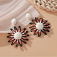 Pink and black raffia woven earrings photographed with soft lighting