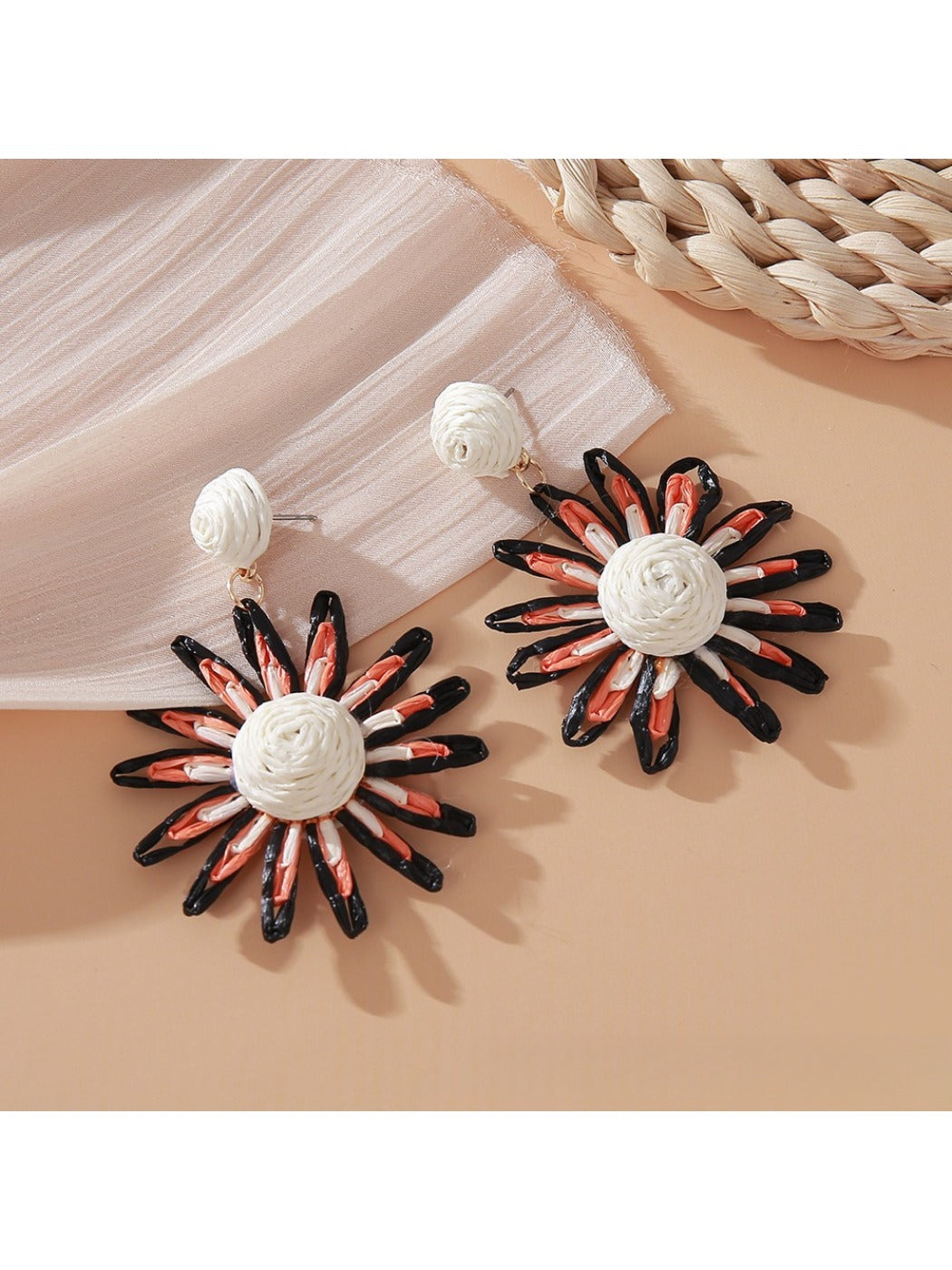 Pink and black raffia woven earrings photographed with soft lighting
