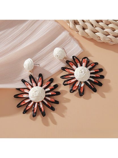 Pink and black raffia woven earrings photographed with soft lighting