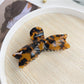 Beau bow shaped hair claw clip with spring mechanism visible