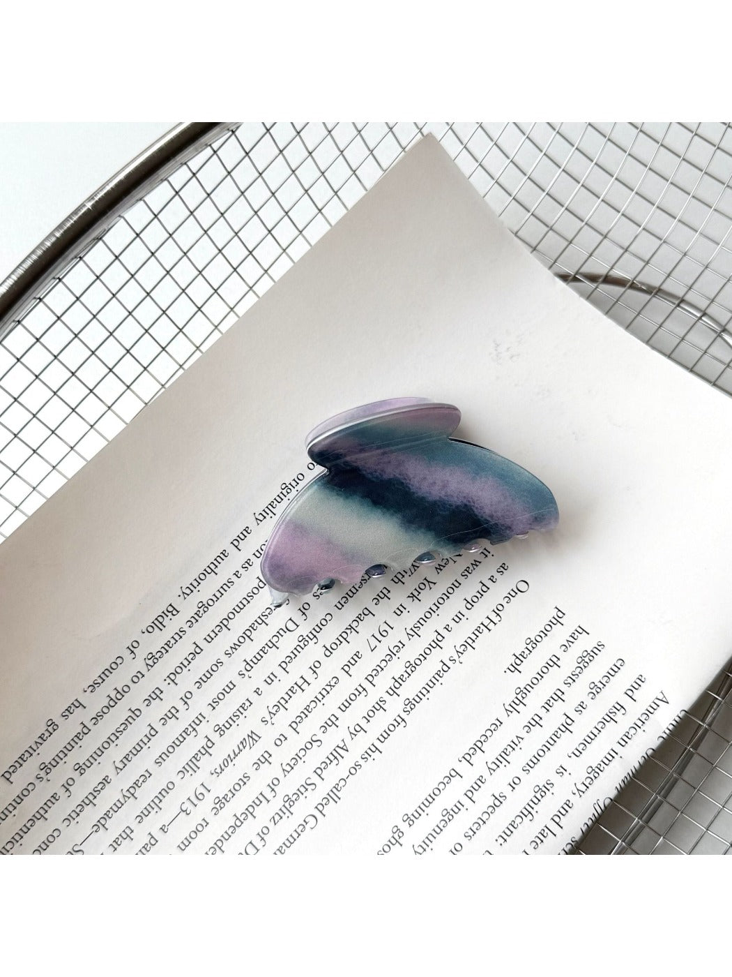 Beau purple hair claw clip held in hand showing size and shape