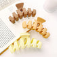 Beau hair claw clip held in hand highlighting size and wavy shape