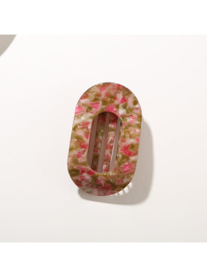 Beau hair clip held in hand illustrating compact size and lightweight design
