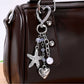 Starfish heart keychain attached to a set of keys on wooden surface