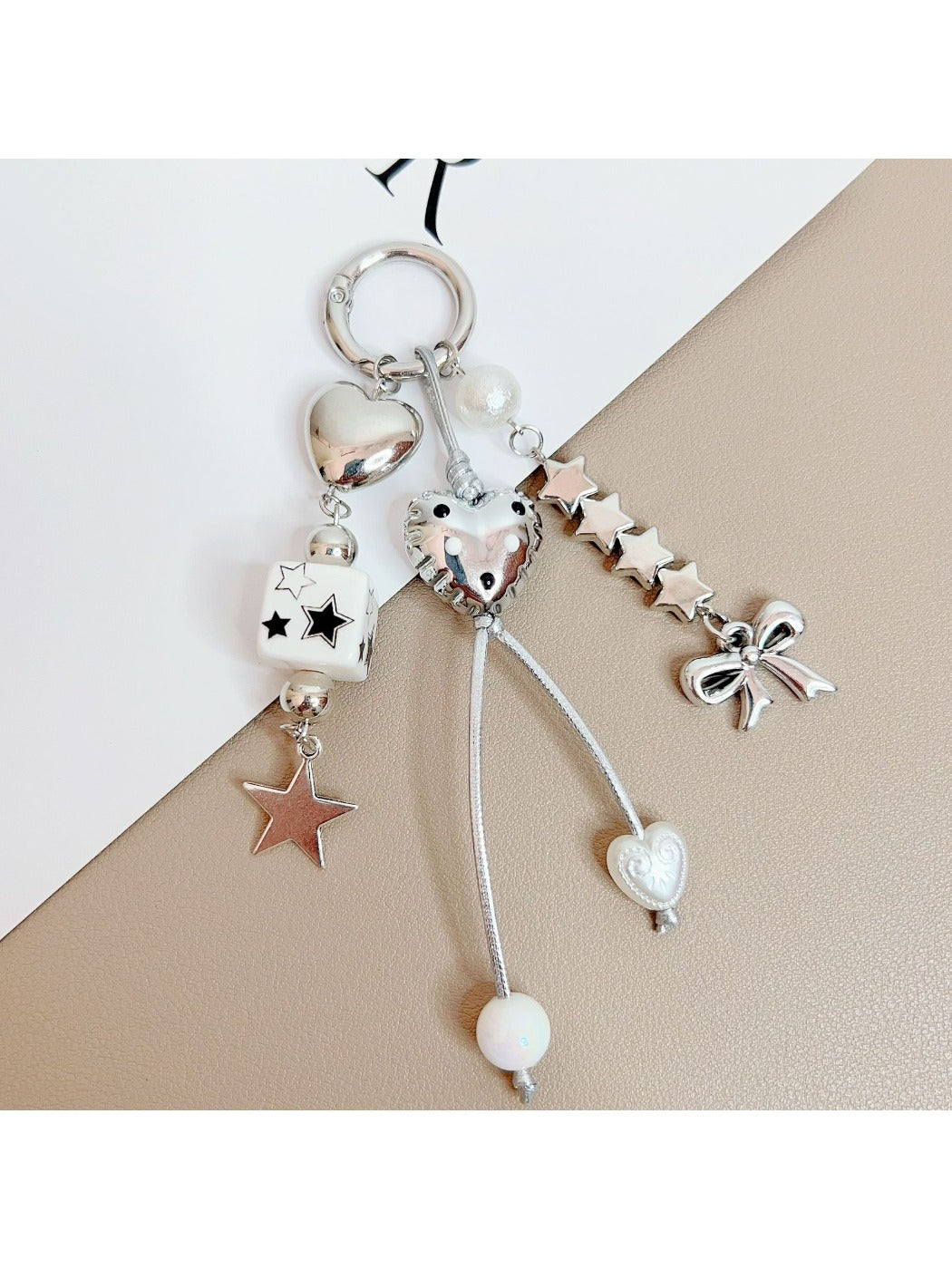 Keypus star and bow charm keychain displayed on wooden surface