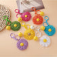 Close-up of raffia woven sunflower shaped keychain with natural fibers