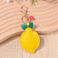 Lemon keychain hanging from a set of keys on a wooden surface