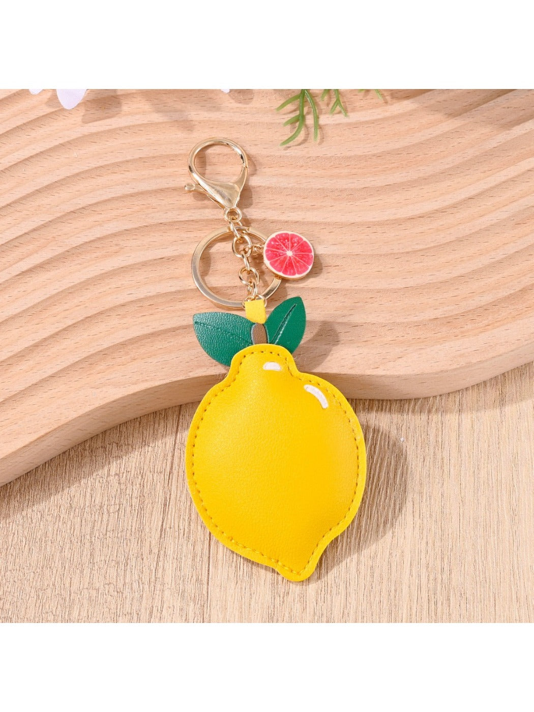 Lemon keychain hanging from a set of keys on a wooden surface