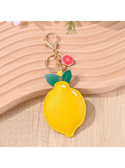 Lemon keychain hanging from a set of keys on a wooden surface