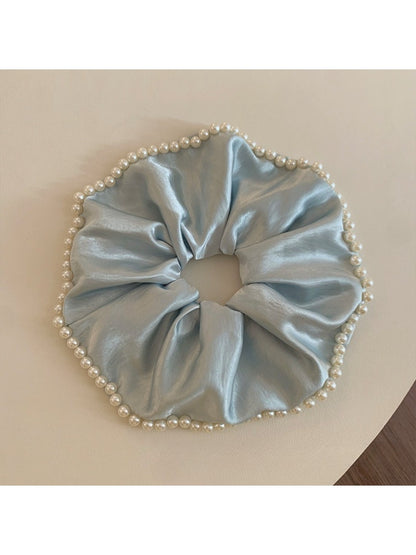 Close-up of Gifty chic satin scrunchie with pearl beads on a white background