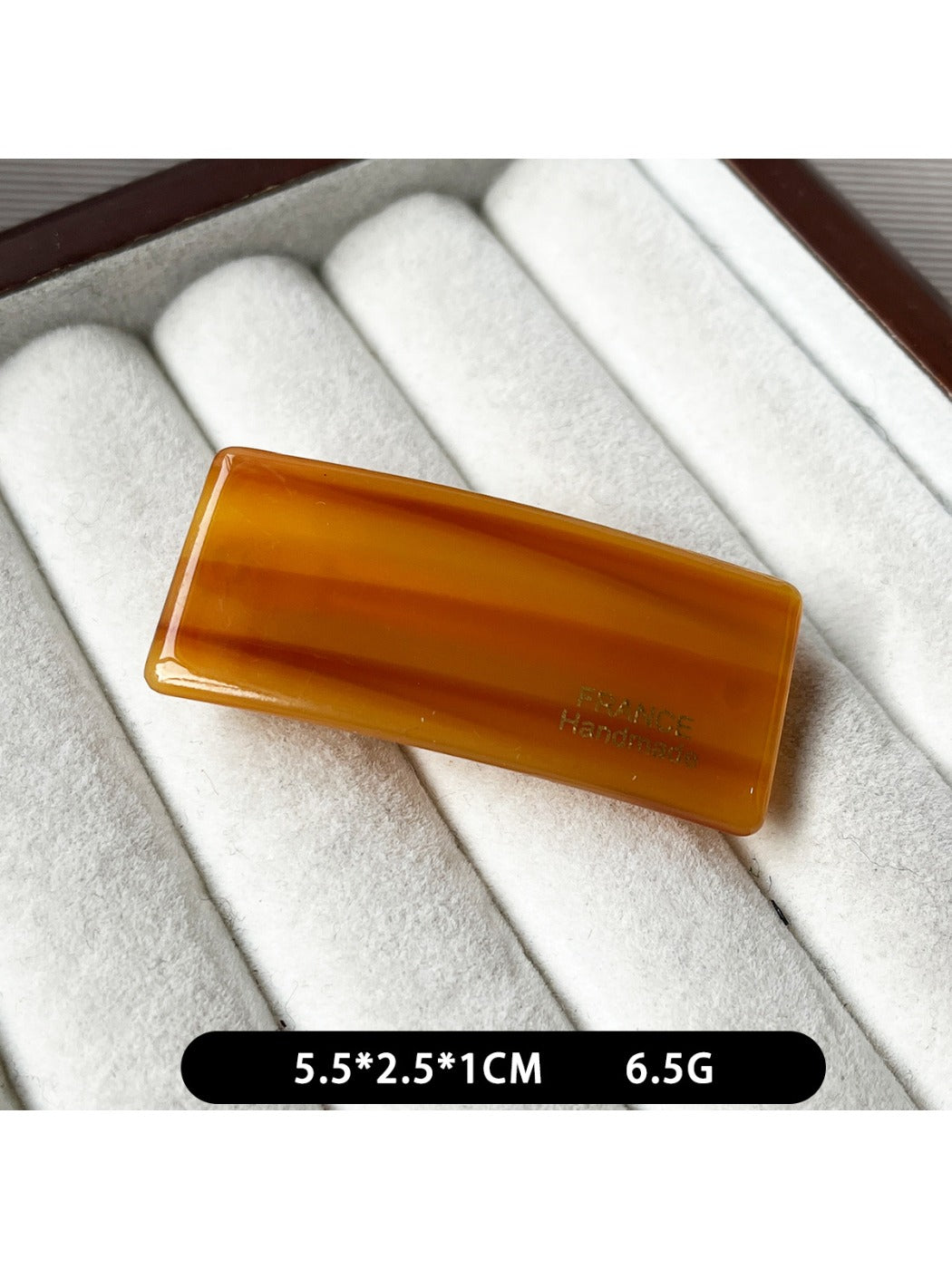 Beau curved bar hair clip positioned diagonally on white surface
