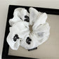 Gifty scrunchie styled in hair, featuring simple gentle floral print