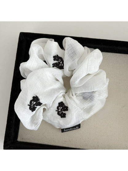 Gifty scrunchie styled in hair, featuring simple gentle floral print