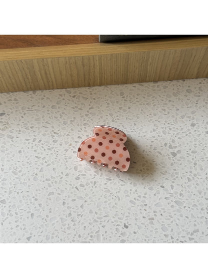 Beau polka dot claw clip styled in a casual half-up hairdo