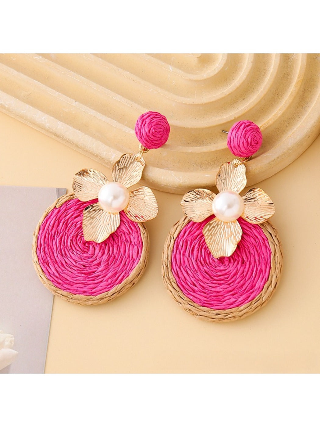 Pair of Earedge chic circular floral drop earrings hanging from a jewelry stand