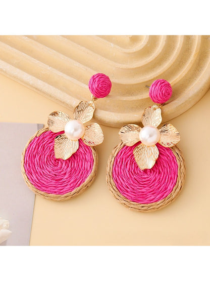Pair of Earedge chic circular floral drop earrings hanging from a jewelry stand