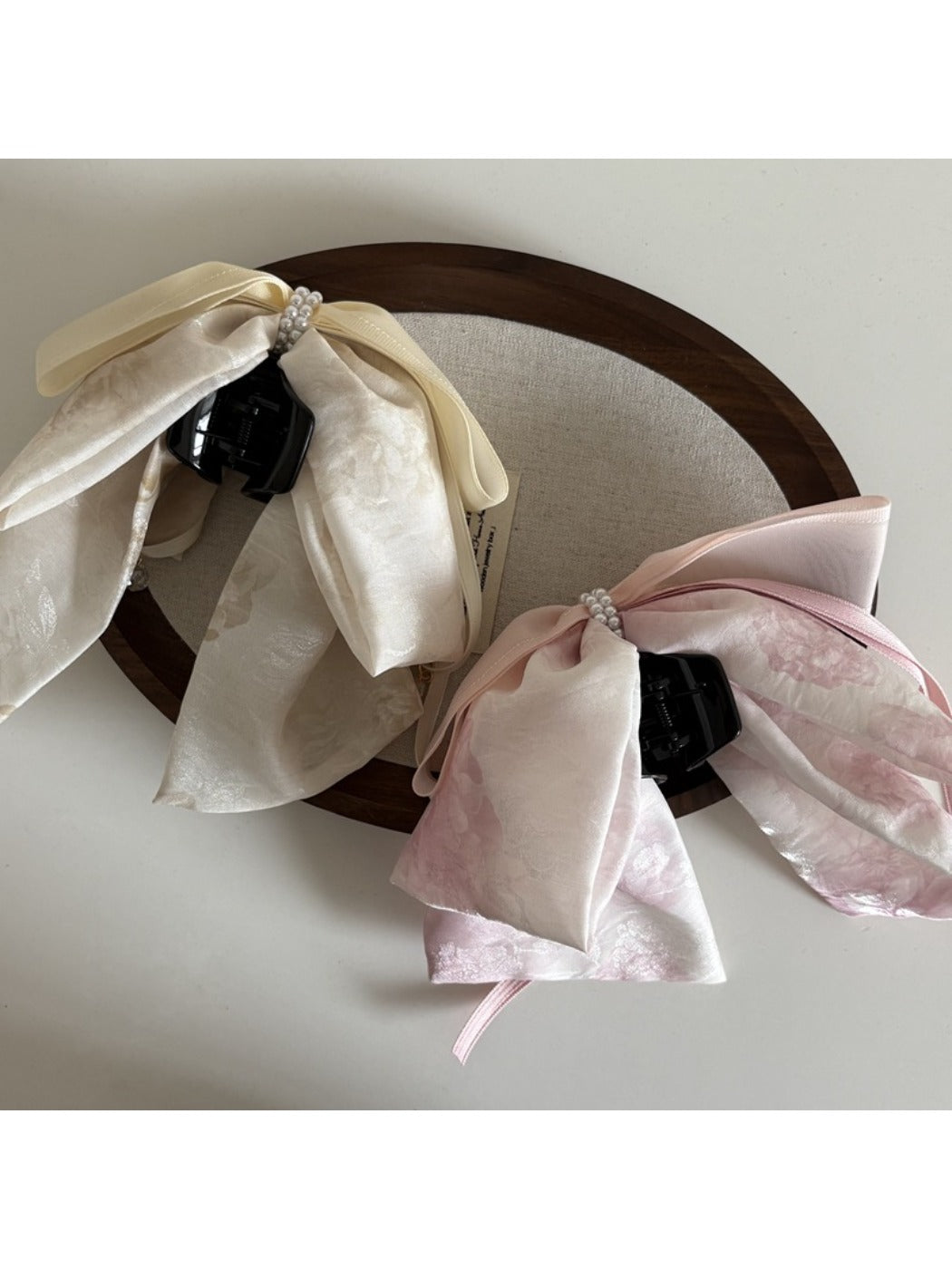 Beau bow ribbon streamer claw clip worn in long brown hair styled in loose waves