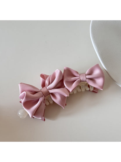 Model wearing Beau satin bow banana clip styled in half-up hairdo