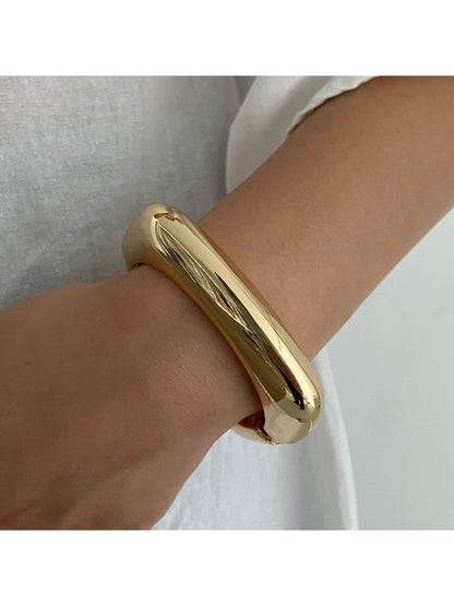 Lovra wide round bangle bracelet displayed on a hand model to show size and fit