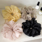 Close-up of a solid color ruched scrunchie with gathered fabric detail