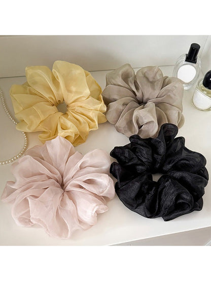 Close-up of a solid color ruched scrunchie with gathered fabric detail