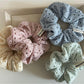 Beige scrunchie with soft texture and subtle dot cutouts displayed on white background