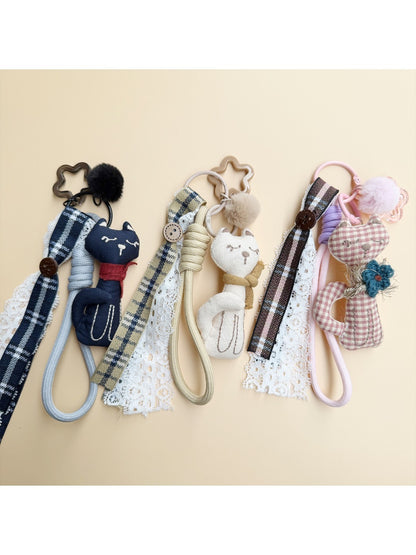 Fabric cat keychain attached to a set of keys on a wooden surface