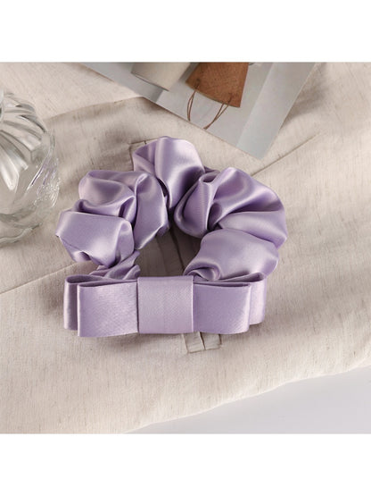 Scrunchie wrapped around a wrist as a stylish accessory in soft pink tones