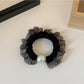 Assorted plaid and polka dot hair ties arranged in a circular pattern