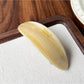 Beau oval hair clip positioned diagonally on a neutral fabric background