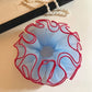 Close-up of blue tulle fabric and red trim on scrunchie
