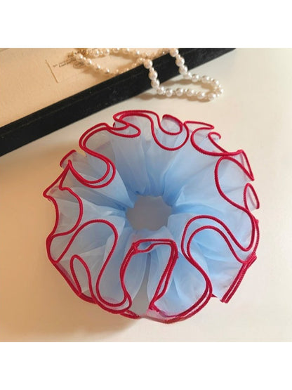 Close-up of blue tulle fabric and red trim on scrunchie