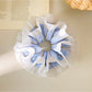 Blue stripe ruffle scrunchie wrapped around a ponytail