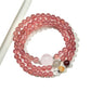 Lovra triple wrap bracelet displayed on a wrist, highlighting the pink crystals and gold details