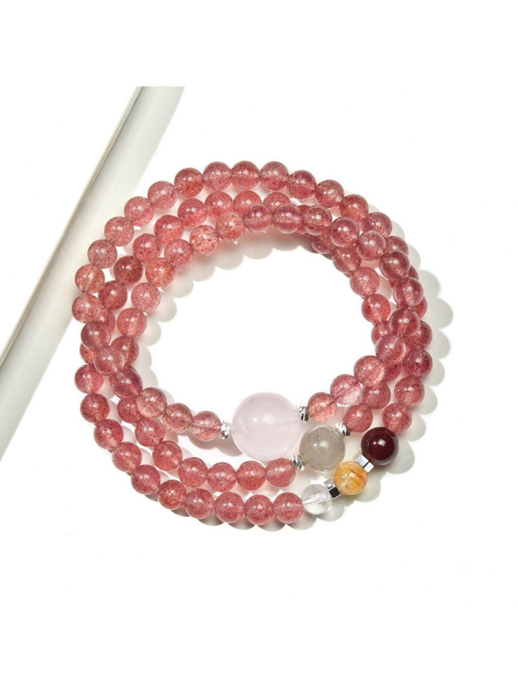 Lovra triple wrap bracelet displayed on a wrist, highlighting the pink crystals and gold details