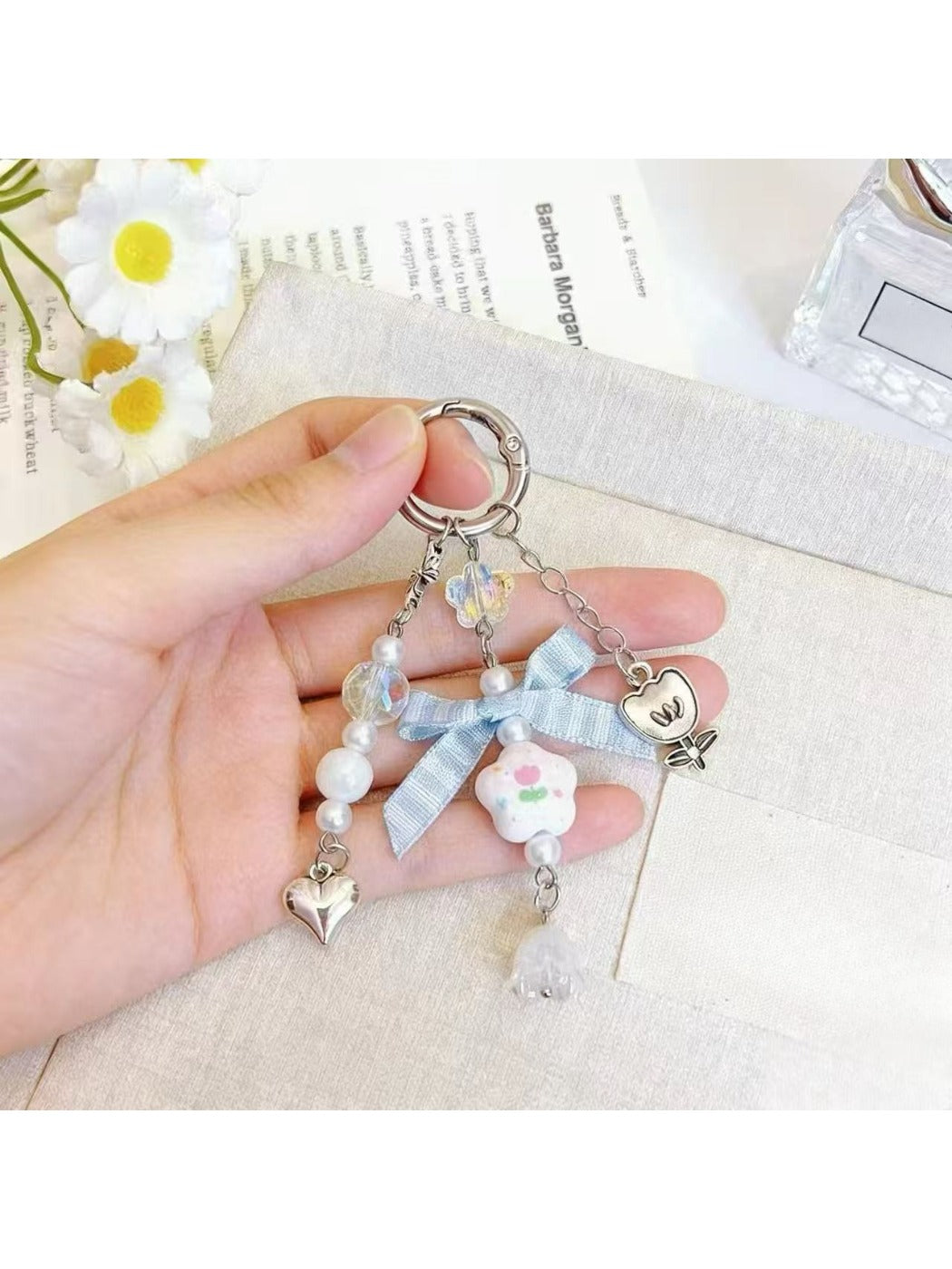 Floral bow charm keychain attached to a set of keys on a wooden surface