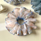 Blue scrunchie featuring a delicate vintage pattern held in hand